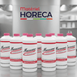 Flacon professionnel de Microclean Mussana sur plan de travail inox en restaurant avec vaisselle à chantilly